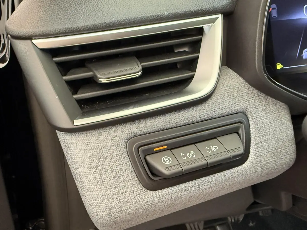Détail du tableau de bord côté gauche de la Renault Clio noire 2025 avec commandes d'éclairage et ventilation.