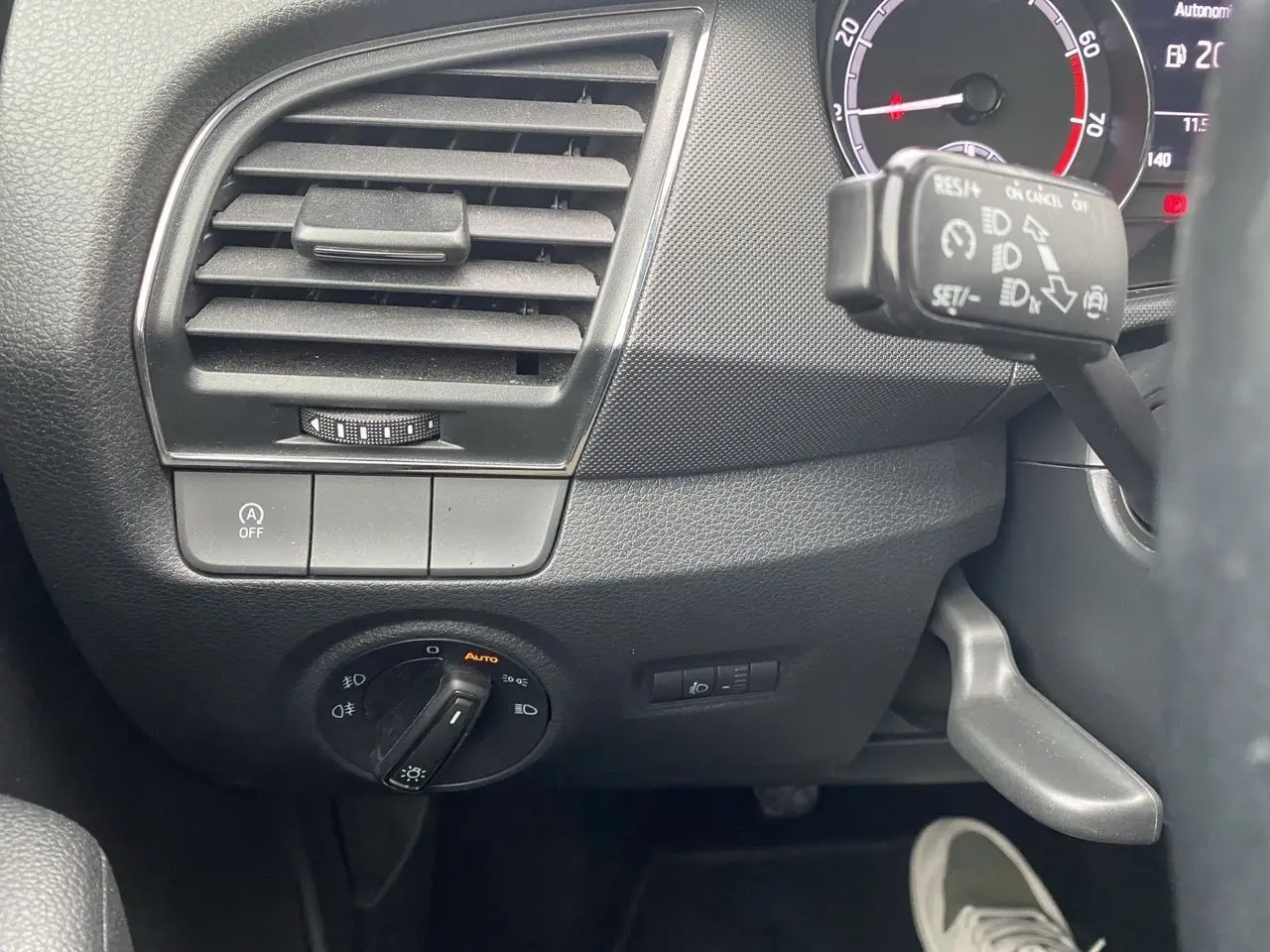 Vue rapprochée du tableau de bord côté gauche d'une Skoda Fabia gris argent, avec commandes d'éclairage et régulateur de vitesse.