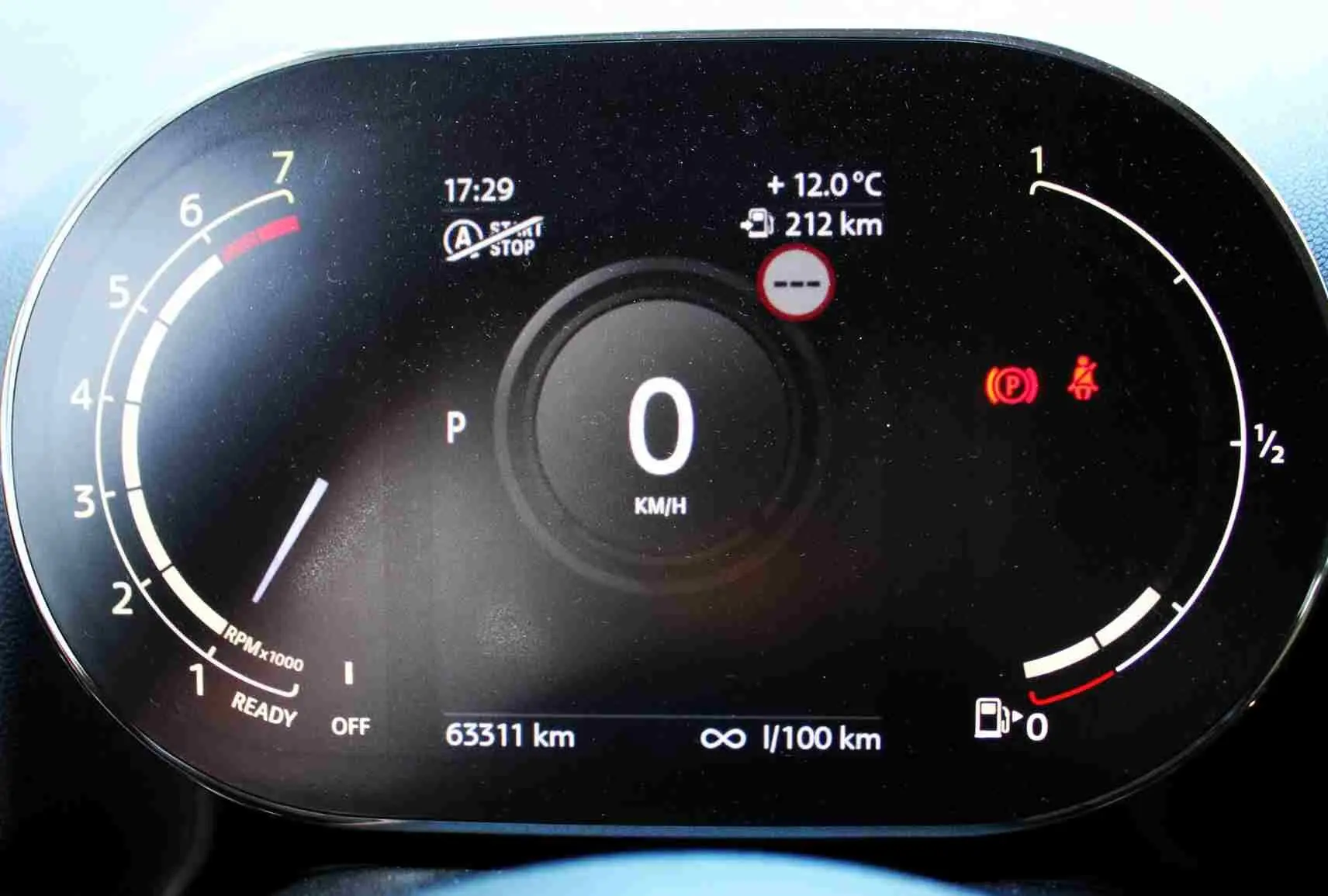 Vue rapprochée du tableau de bord numérique du MINI Countryman gris perle, affichant la vitesse à zéro et divers indicateurs.