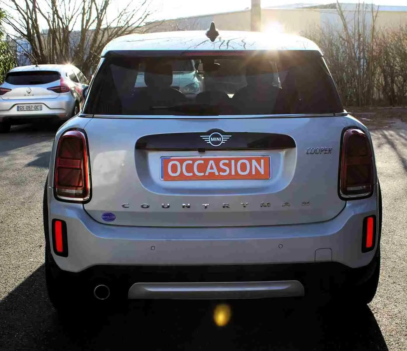 Vue arrière d'une MINI Countryman gris perle métal avec toit noir, feux arrière foncés et plaque "OCCASION" orange.
