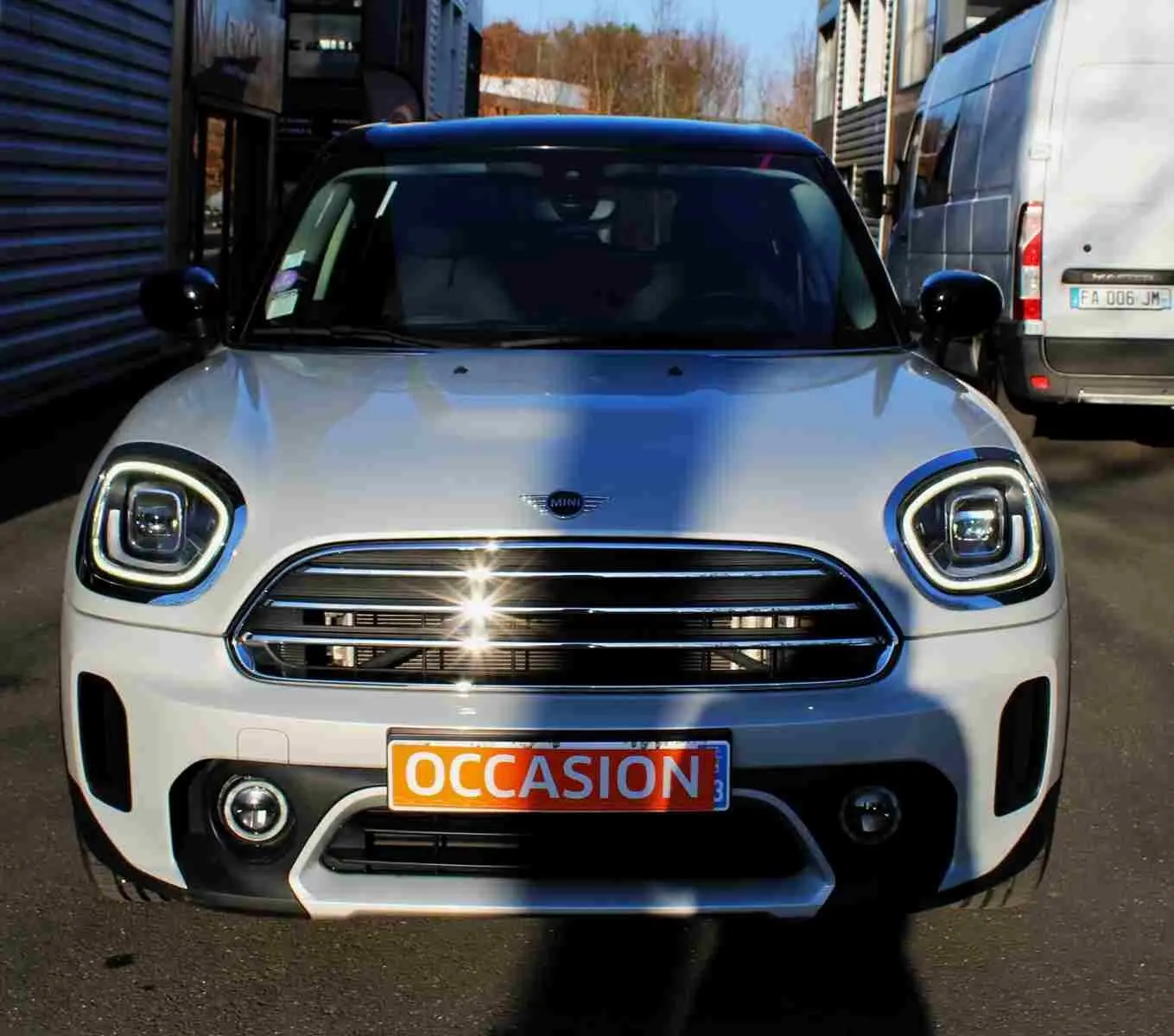 Vue avant d'un MINI Countryman gris perle métal avec toit noir, calandre chromée et plaque "OCCASION" visible.