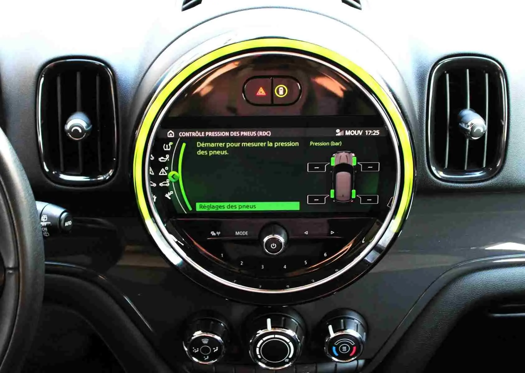 Vue rapprochée du tableau de bord du MINI Countryman gris perle, avec écran central rond affichant la pression des pneus.