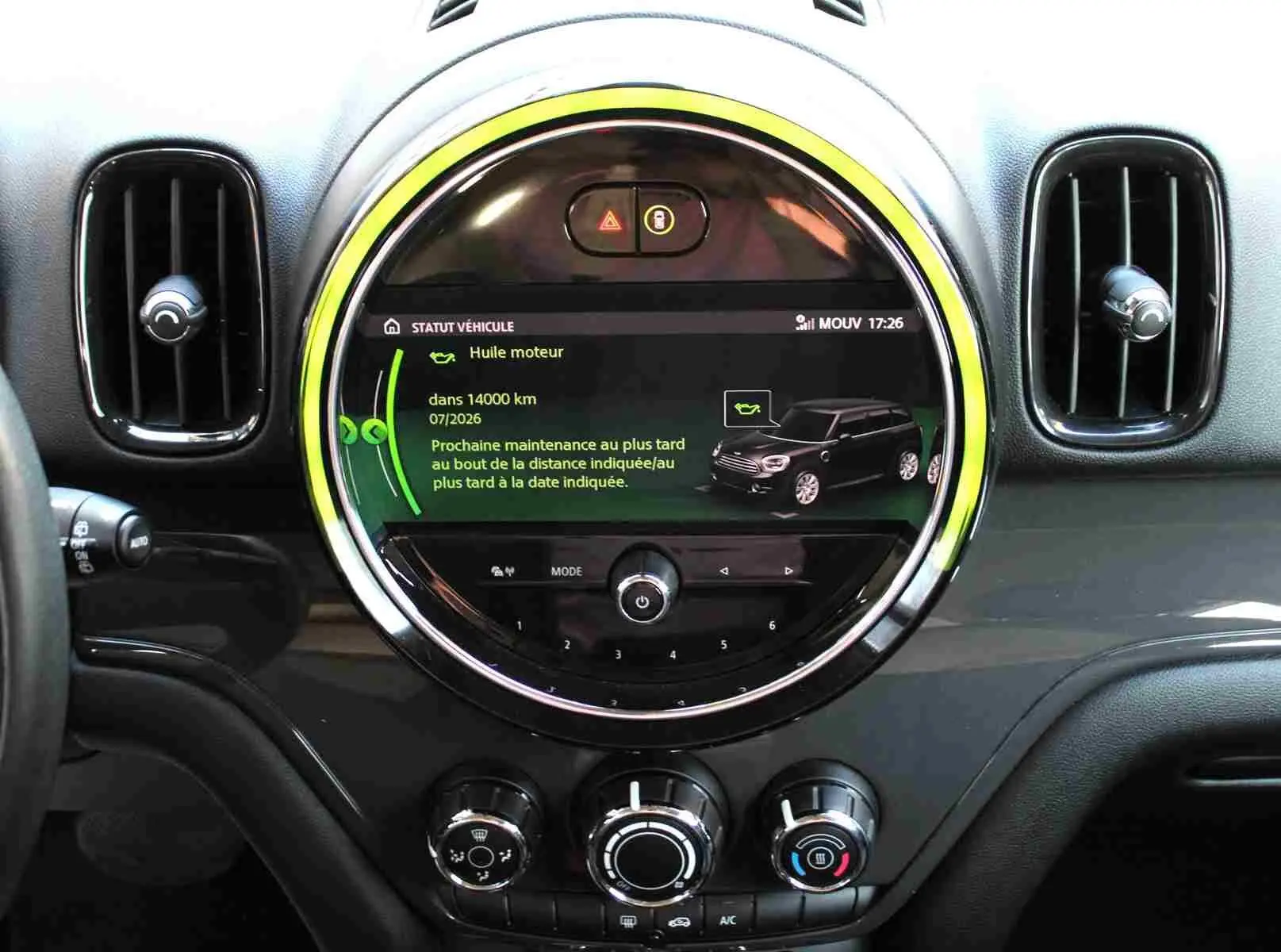 Vue rapprochée du tableau de bord du MINI Countryman gris perle, avec écran central circulaire affichant le statut moteur.