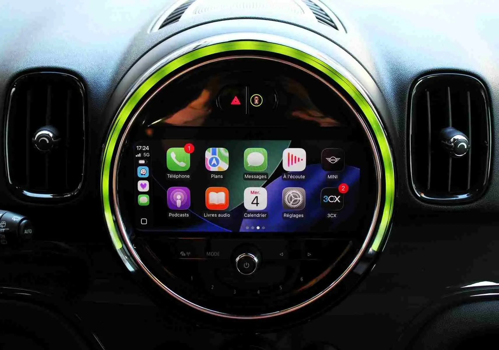 Vue rapprochée du tableau de bord du MINI Countryman avec écran tactile central entouré d'un anneau lumineux vert.