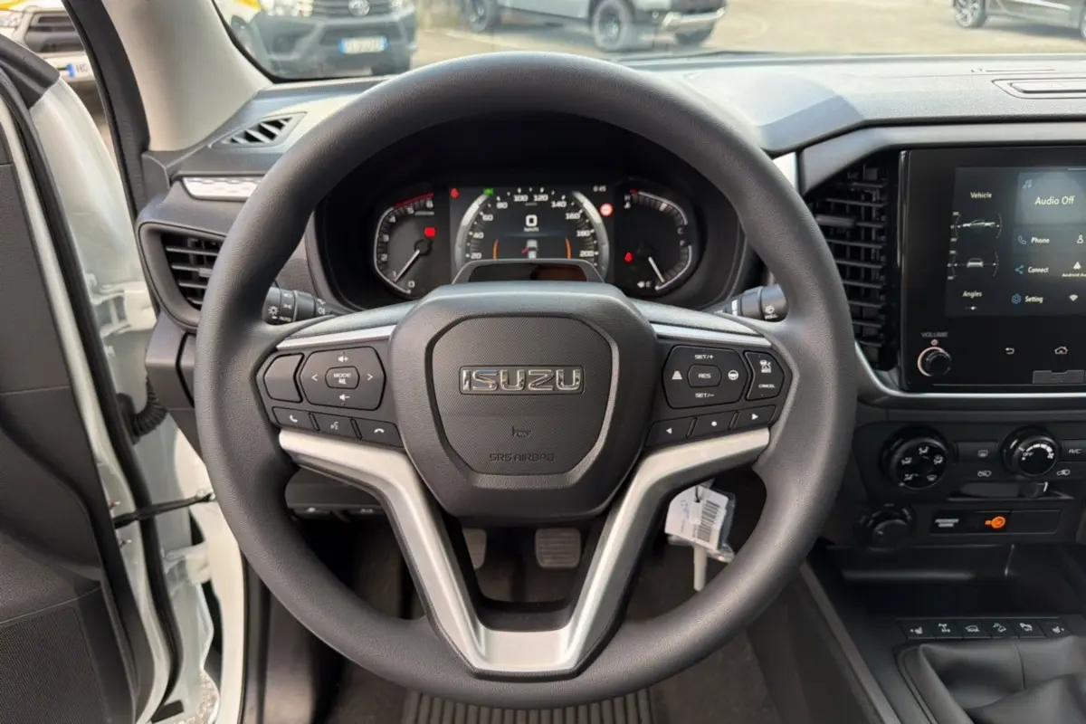 Vue intérieure centrée sur le volant multifonctions noir d'un Isuzu D-MAX 2026 avec tableau de bord et écran tactile.
