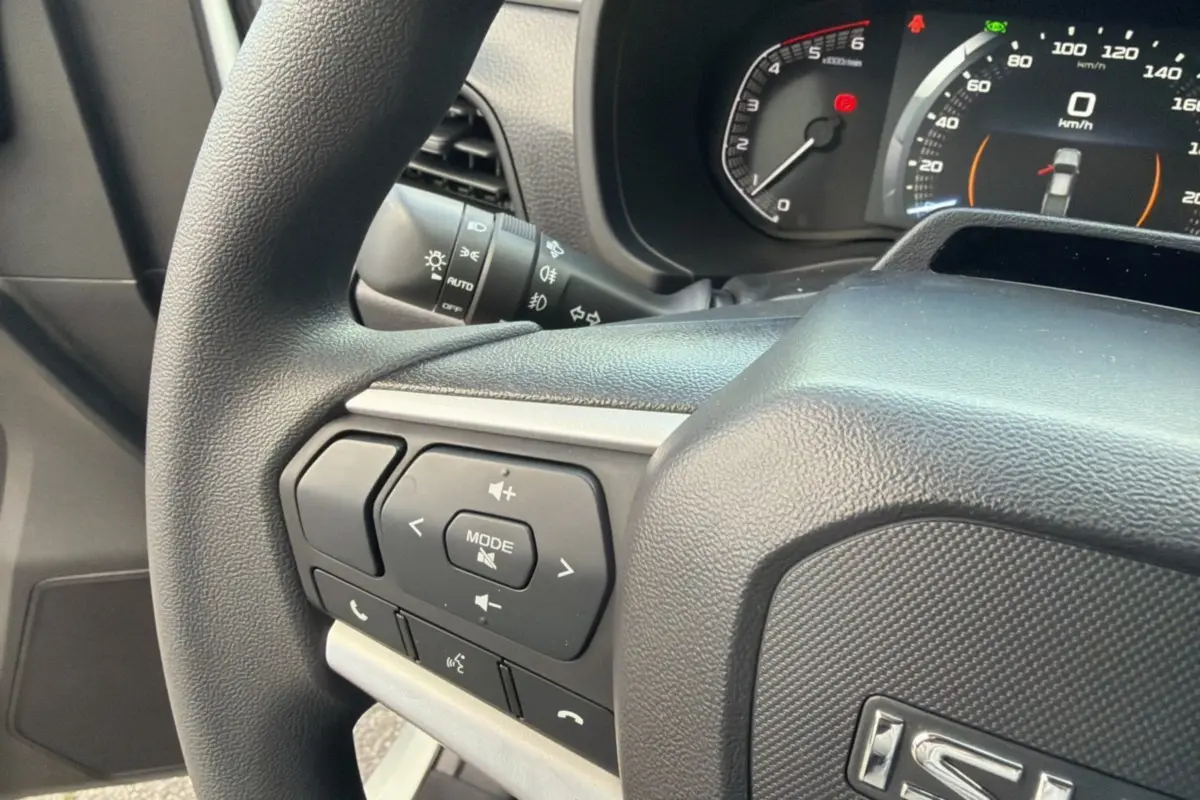 Gros plan sur le volant noir de l'Isuzu D-MAX 2026 avec commandes multifonctions et tableau de bord digital.