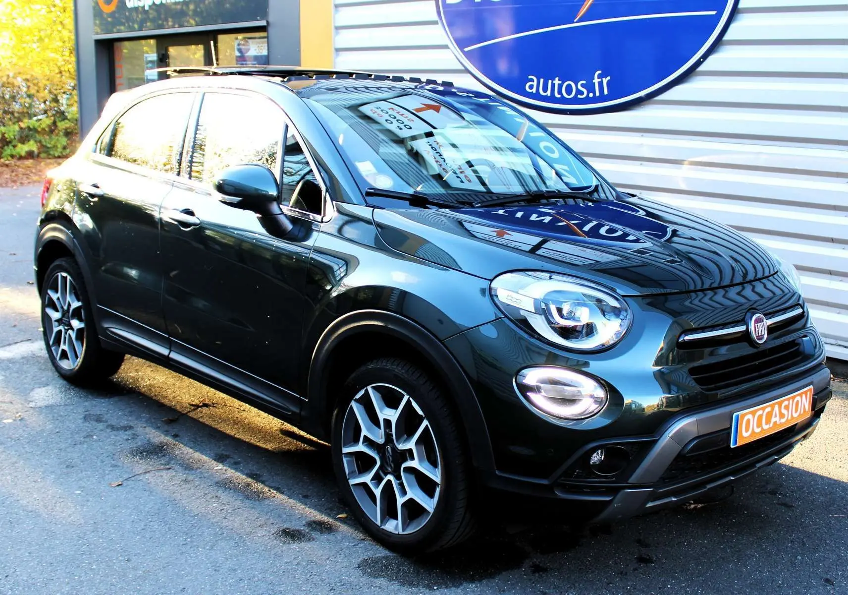 Vue 3/4 avant droit d'un FIAT 500X vert Toscane métallisé avec jantes alliage bicolores et calandre noire.
