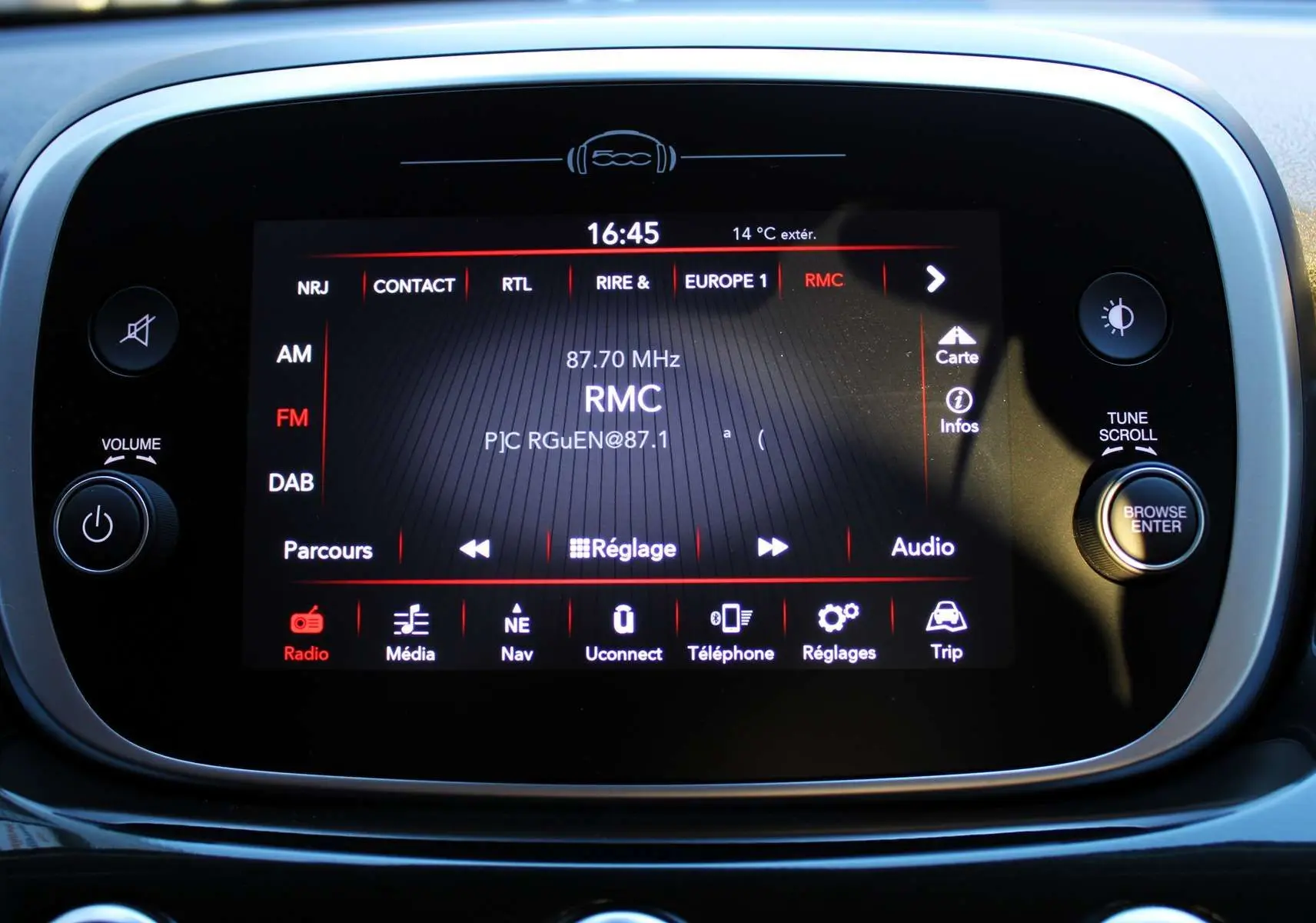 Écran tactile central du tableau de bord de la Fiat 500X affichant la radio RMC en mode FM, avec commandes autour.