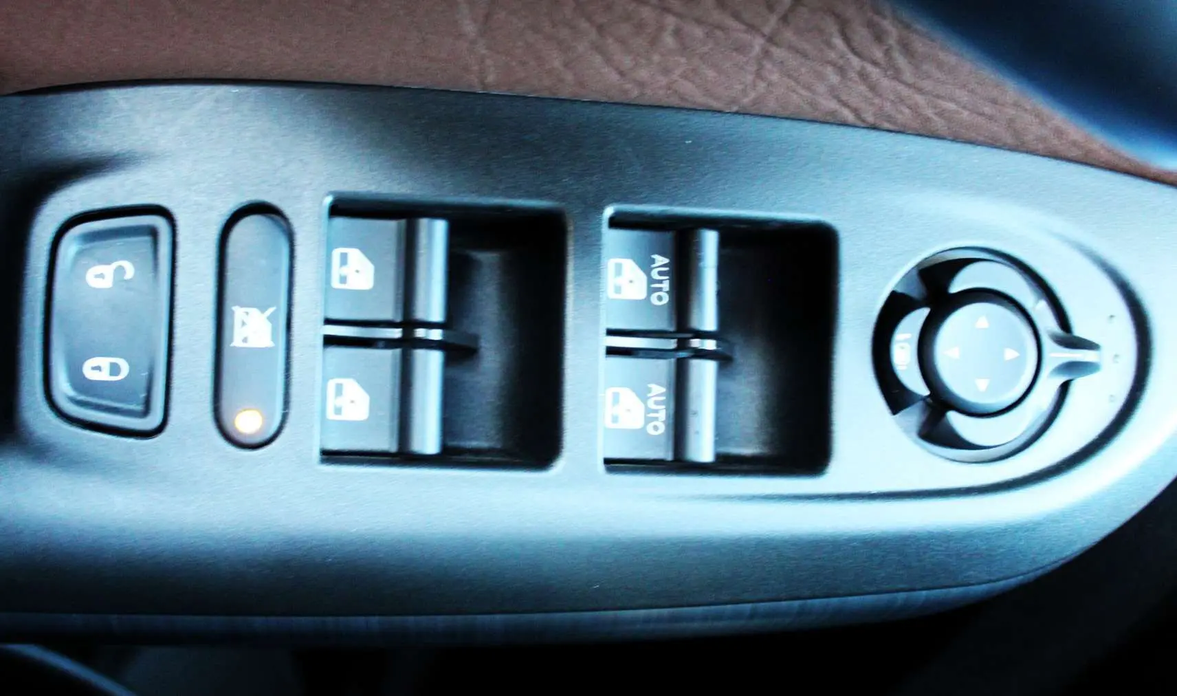 Gros plan sur les commandes de lève-vitres et réglage des rétroviseurs côté conducteur d'une FIAT 500X 2019.