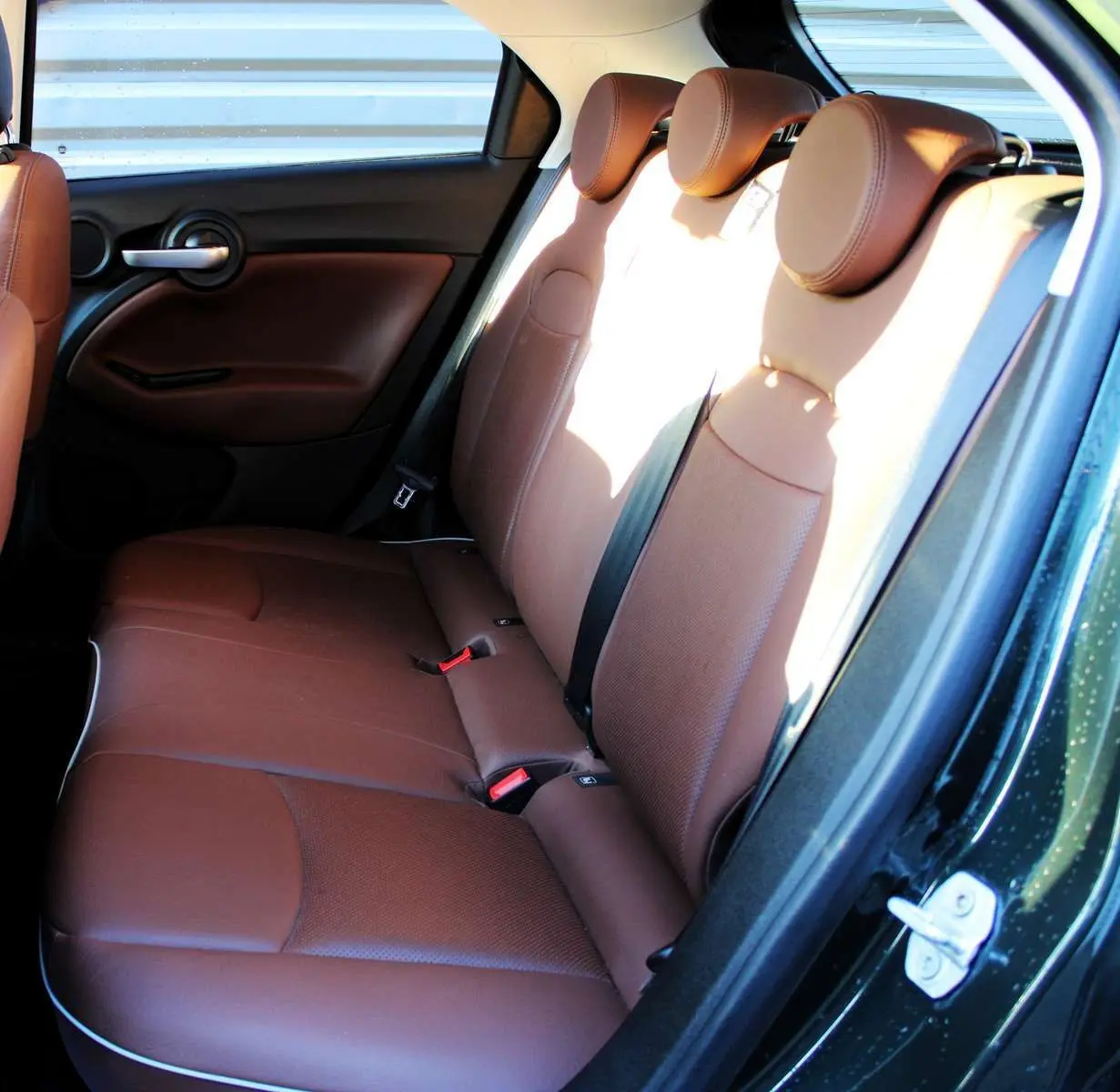 Vue intérieure côté droit des sièges arrière en cuir marron d'une FIAT 500X 2019 vert Toscane métallisé.