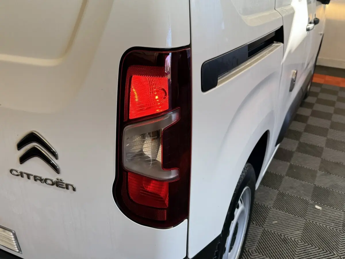 Feu arrière droit allumé du Citroën Berlingo blanc, vue rapprochée du côté arrière droit du véhicule.