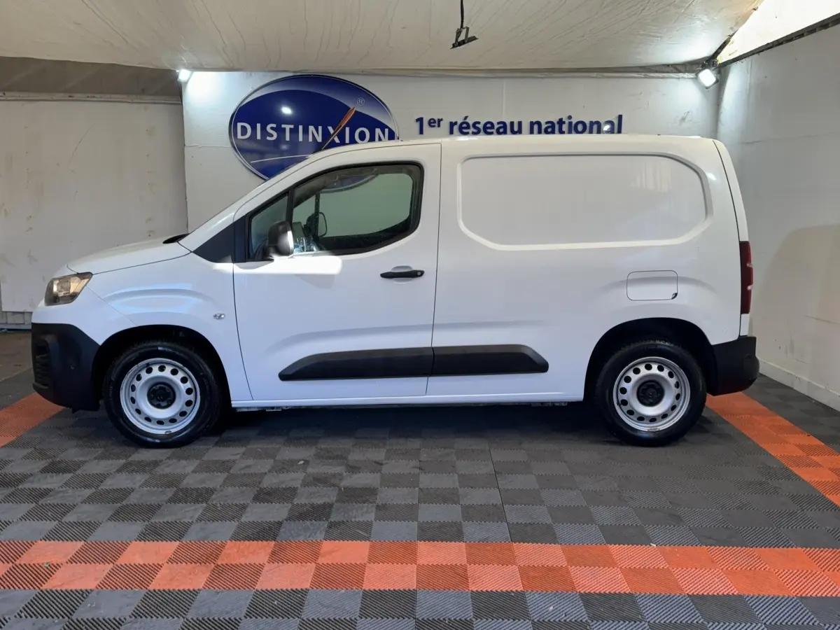 Vue de profil côté gauche d’un utilitaire Citroën Berlingo blanc avec jantes acier et protections noires.