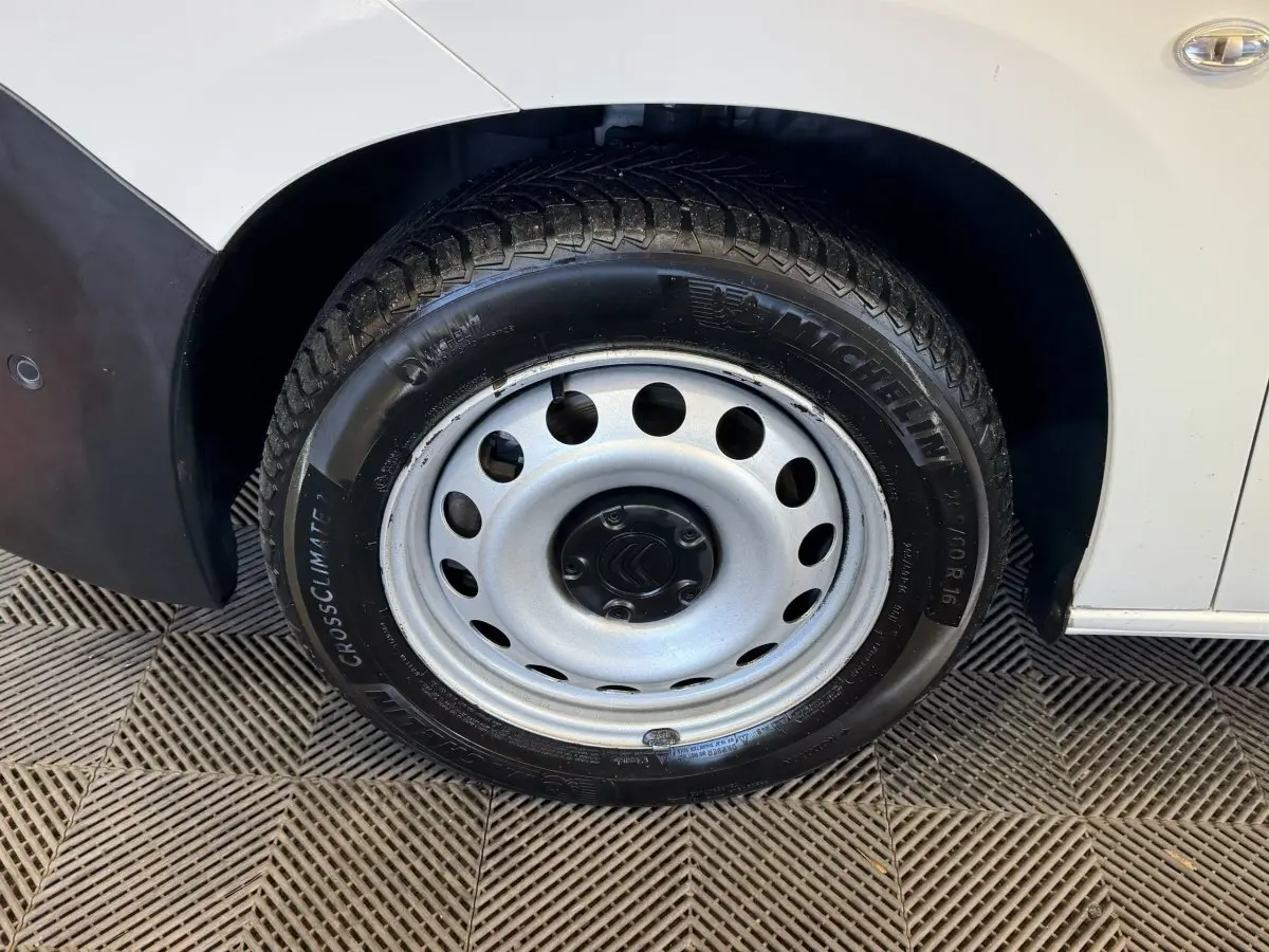 Gros plan sur la roue avant droite en jante acier grise du Citroën Berlingo blanc de 2020.