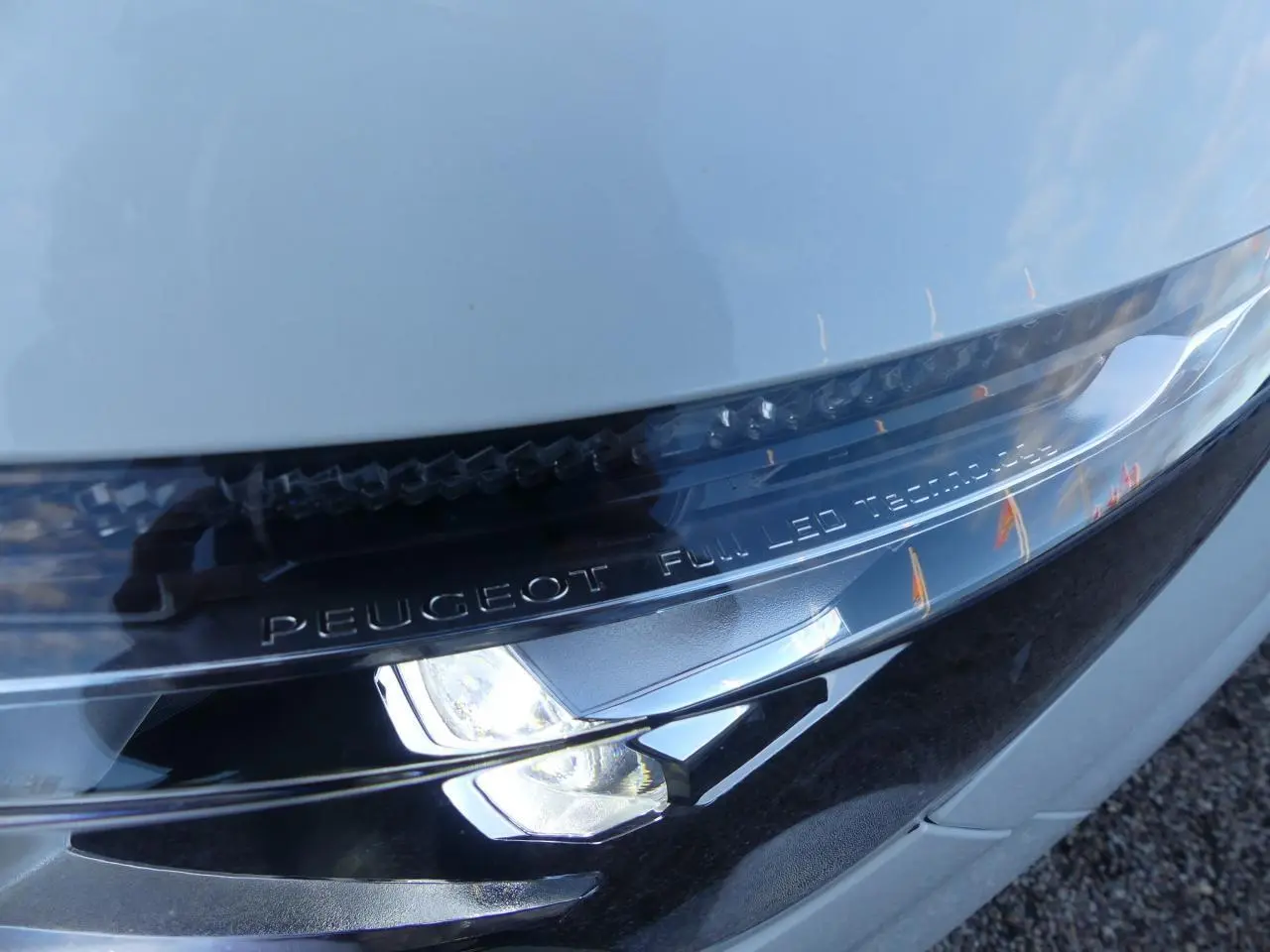 Gros plan sur le phare avant droit blanc nacré du Peugeot 3008 GT Line avec inscription Full LED Technology.