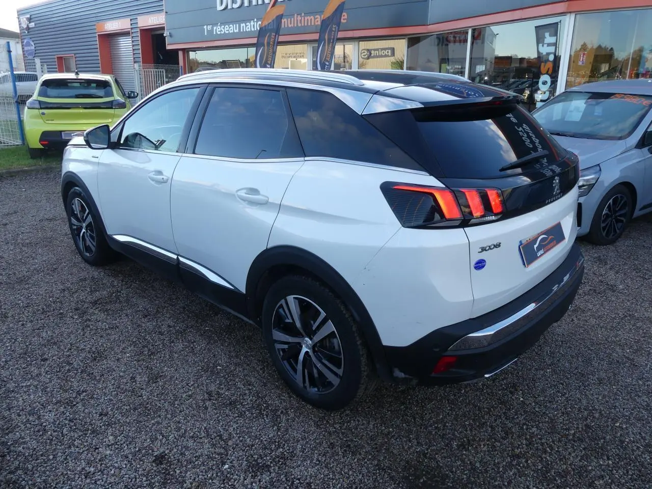 Vue 3/4 arrière droite du Peugeot 3008 blanc nacré avec toit noir et feux arrière LED caractéristiques.