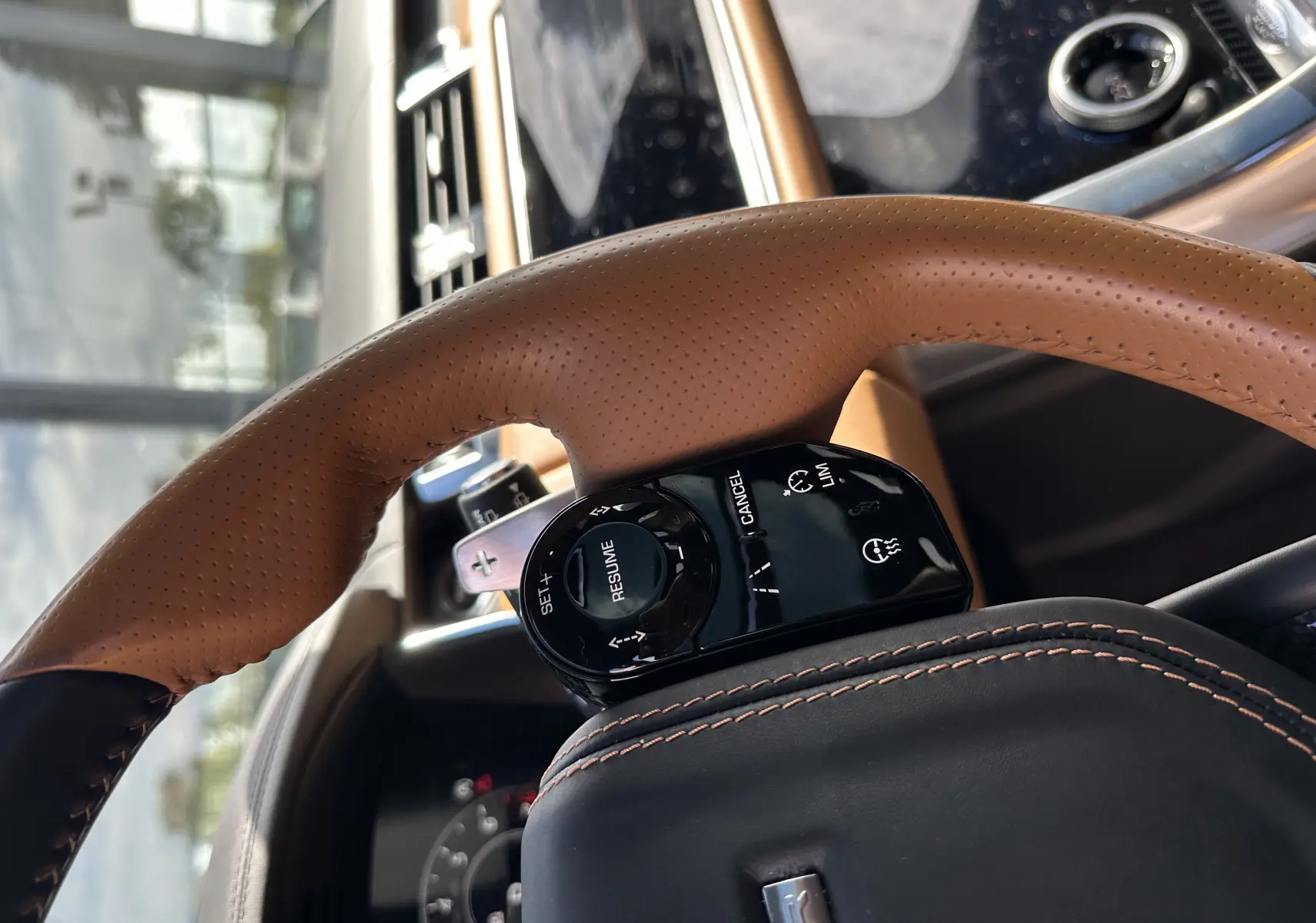 Gros plan sur le volant en cuir marron perforé du Range Rover Sport SVR 2020 avec commandes de régulateur de vitesse intégrées.