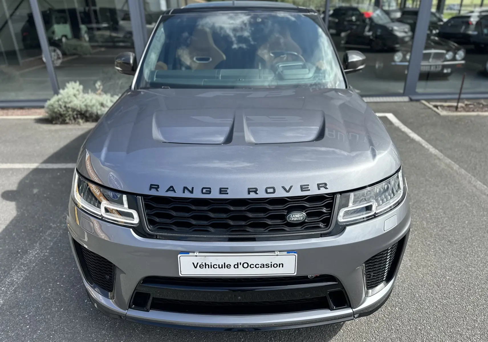Vue avant d'un Range Rover Sport gris foncé 2020 avec capot ventilé et calandre noire distinctive.