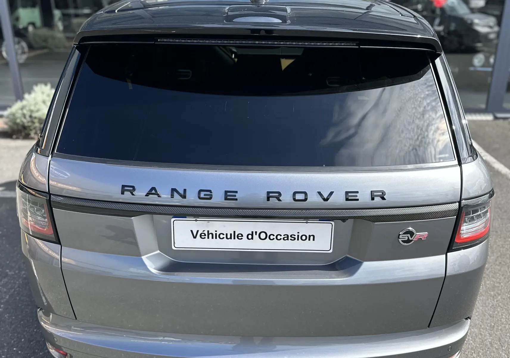 Vue arrière d'un Range Rover Sport gris foncé 2020 avec logo SVR et double sortie d'échappement rectangulaire.