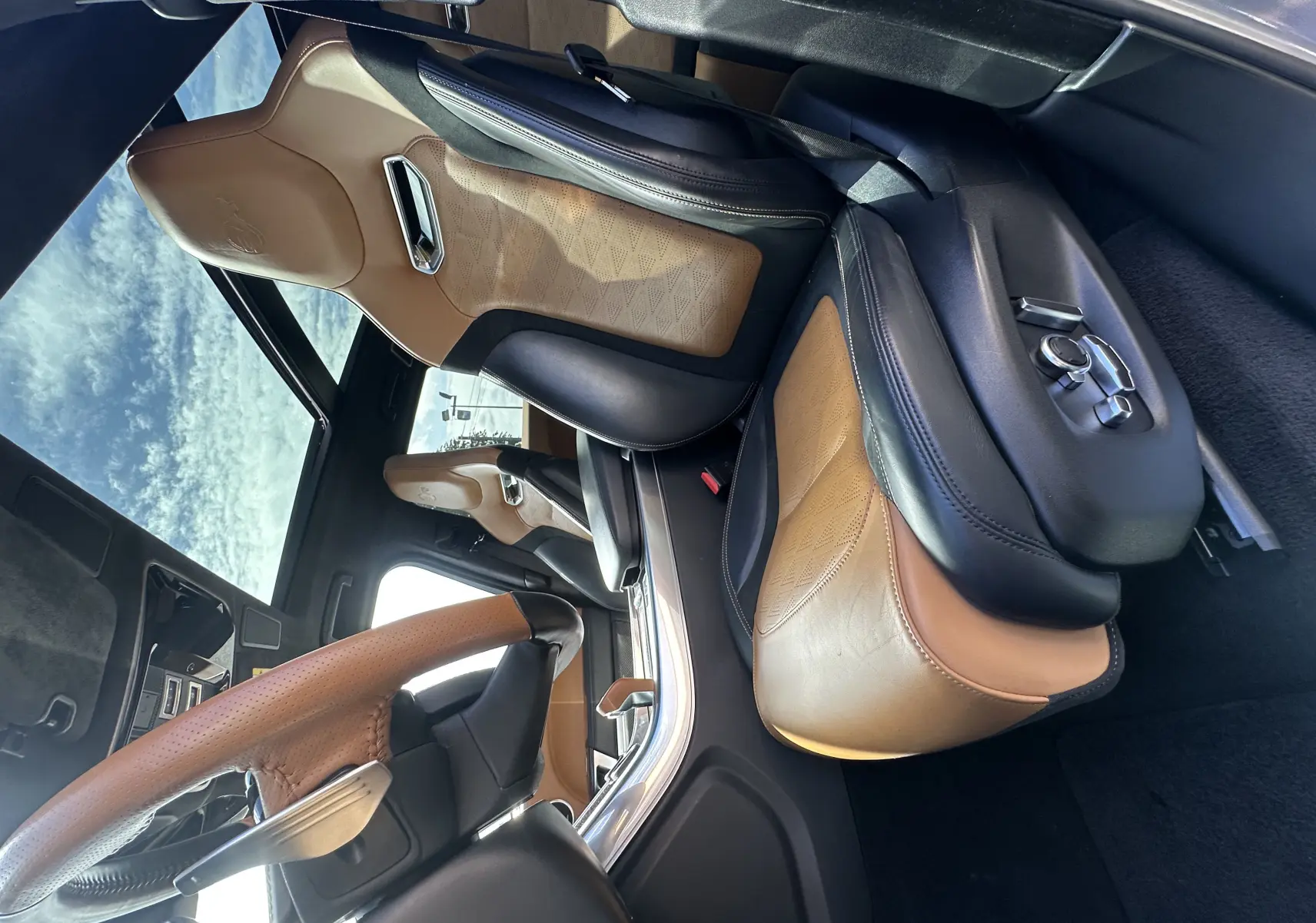 Intérieur du Range Rover Sport SVR 2020, vue côté conducteur, sièges cuir bicolore marron et noir avec finitions premium.