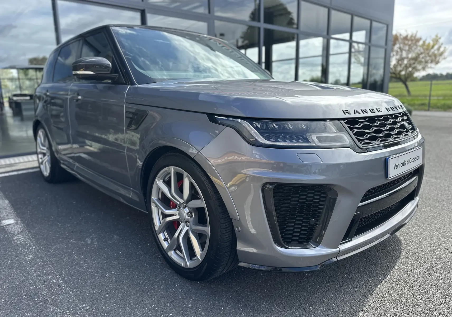 Vue 3/4 avant gauche du Range Rover Sport SVR Carbon Edition gris foncé avec jantes alliage et étriers rouges.