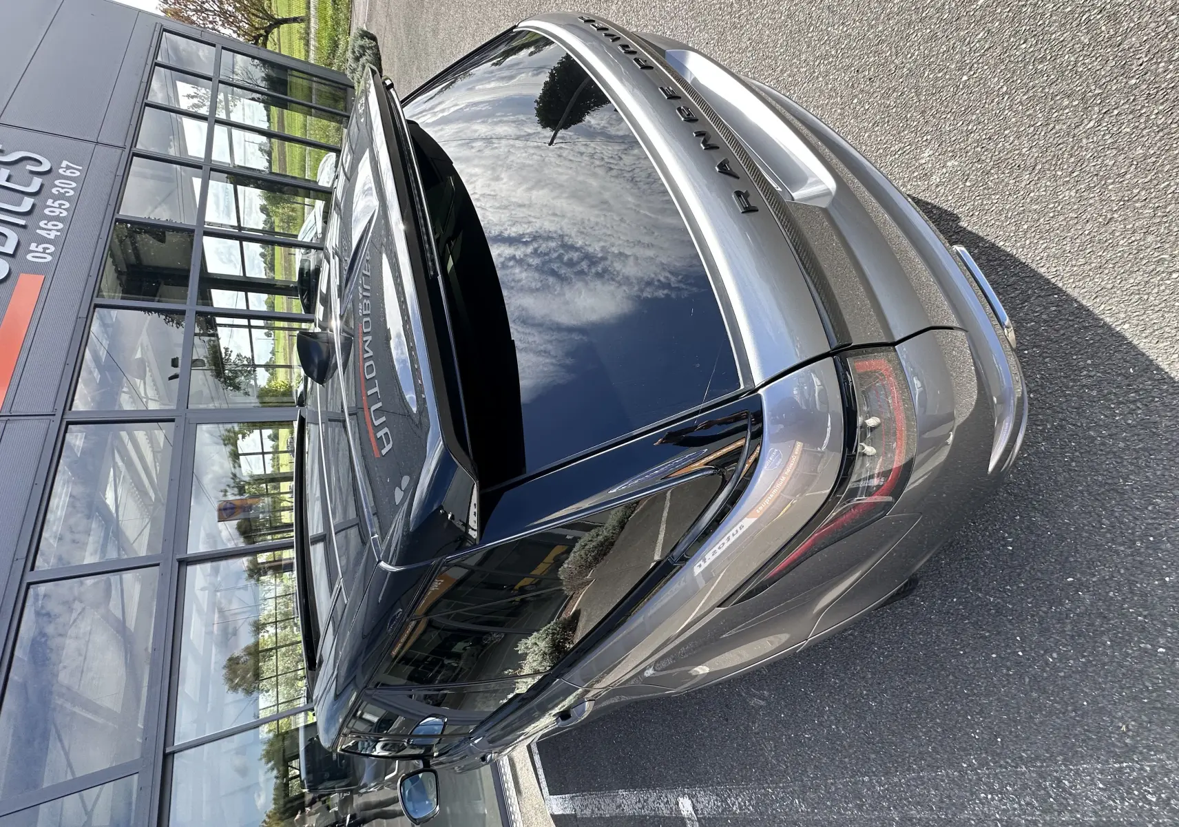 Vue 3/4 arrière du Range Rover Sport SVR Carbon Edition 2020 en gris foncé, avec toit noir brillant et feux arrière LED.