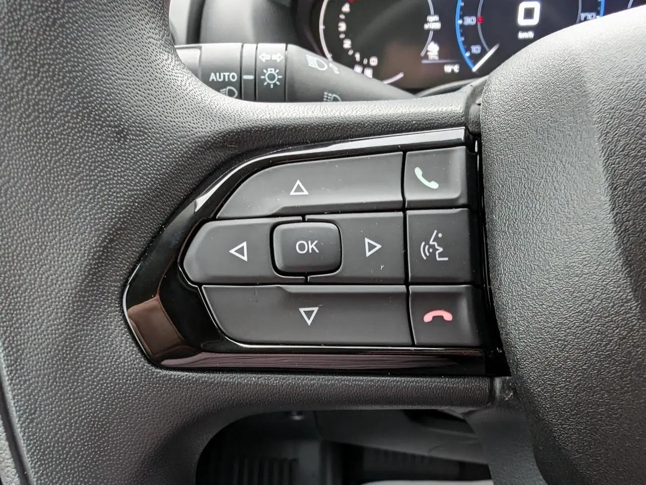 Gros plan sur les commandes multifonctions du volant côté gauche du Citroën Jumper blanc 2025.