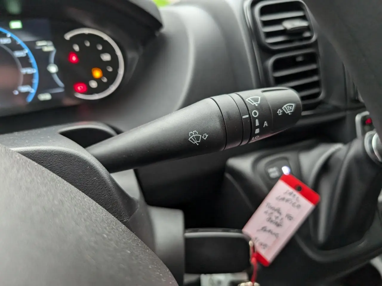 Gros plan sur la commande d'essuie-glace du tableau de bord du Citroën Jumper blanc 2025, intérieur noir.