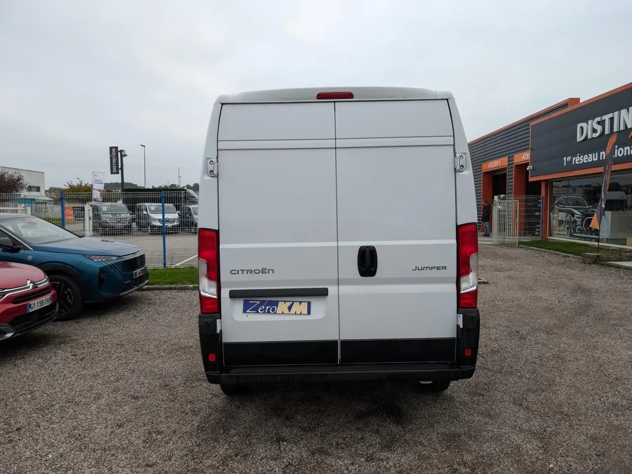 Vue arrière d'un utilitaire Citroën Jumper blanc avec portes battantes et feux rouges verticaux.