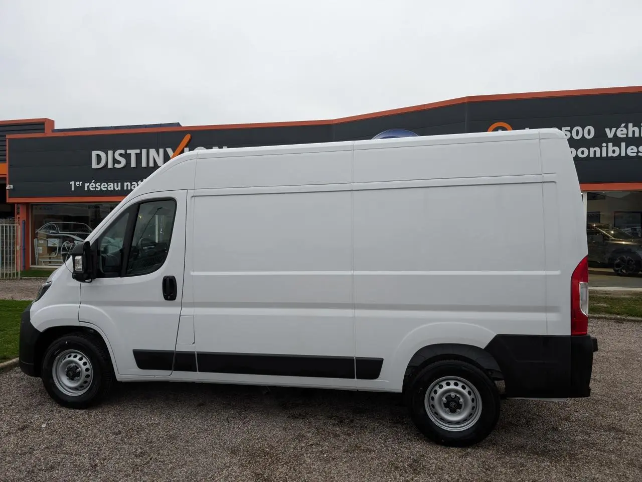 Vue de profil côté gauche d'un utilitaire Citroën Jumper blanc avec porte latérale coulissante et roues acier.