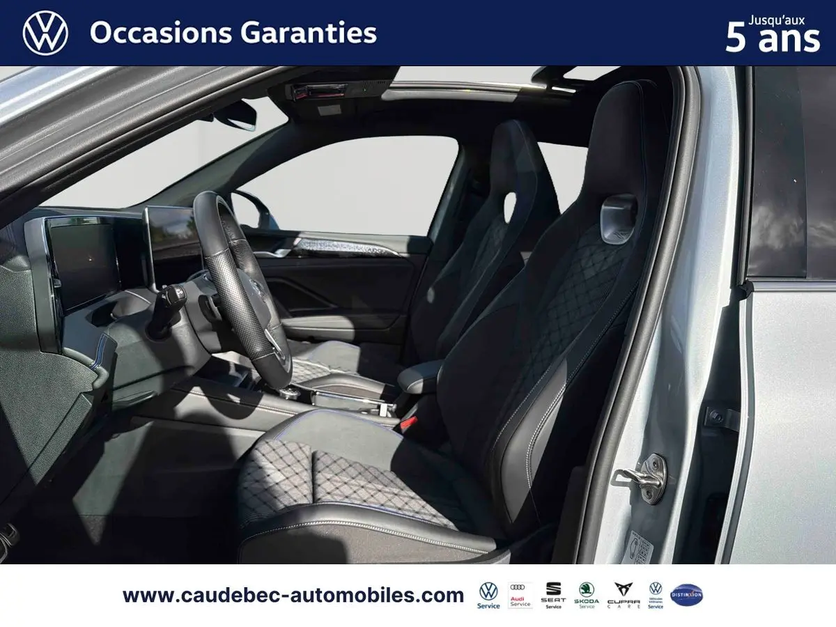 Vue intérieure côté conducteur du Volkswagen Tiguan argent Dolomite 2025 avec sièges sport et toit ouvrant panoramique.