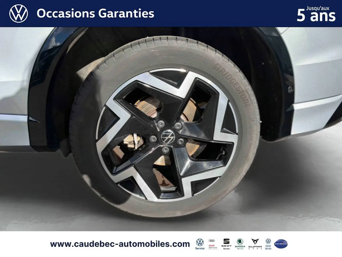 Gros plan sur la roue avant droite du Volkswagen Tiguan 2025 argent Dolomite avec jante alliage noir et argentée.