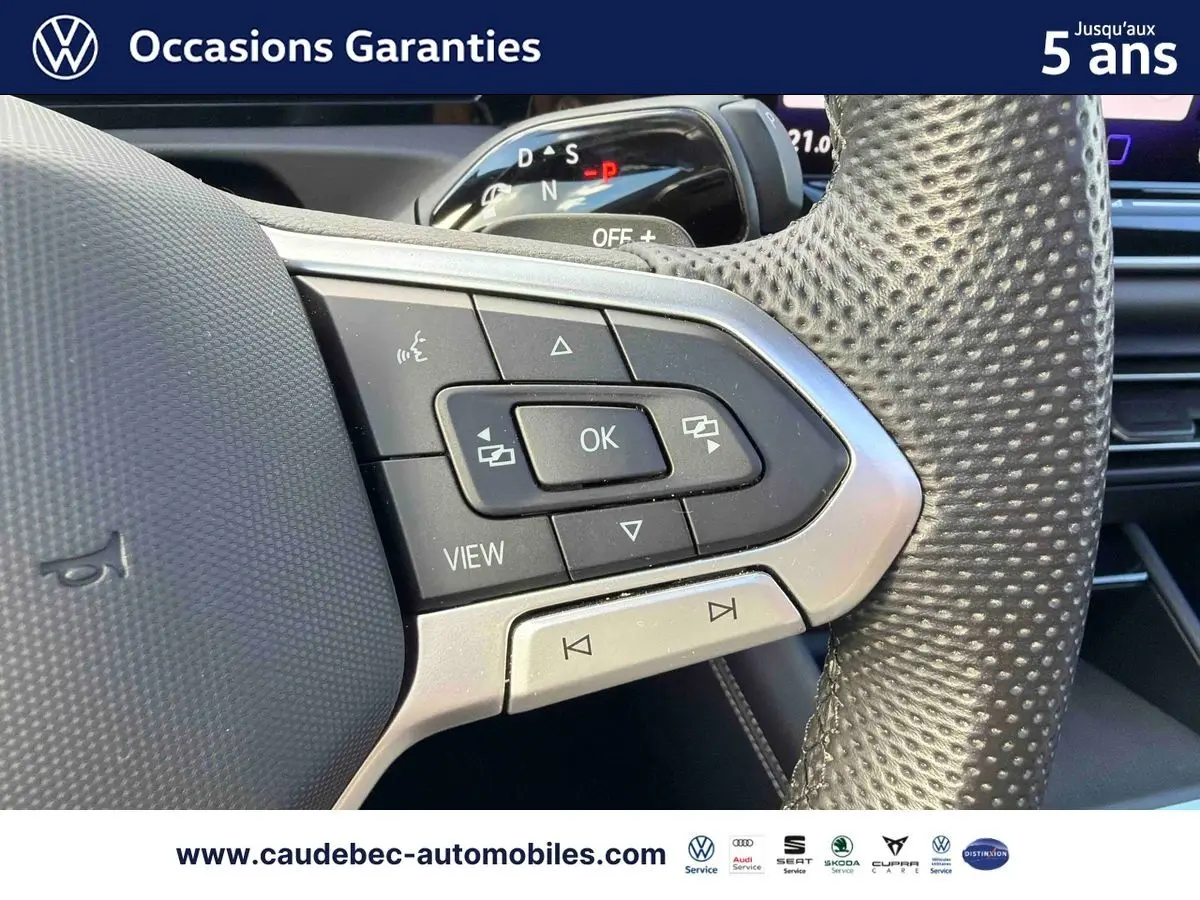 Gros plan sur les commandes multifonctions du volant en cuir perforé du Volkswagen Tiguan argent Dolomite 2025.