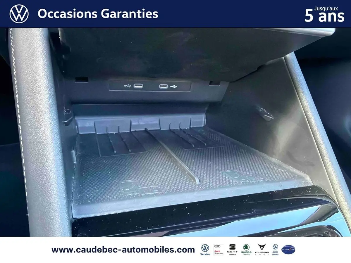 Gros plan sur la console centrale avec prises USB-C et espace de rangement du Volkswagen Tiguan eHybrid argent.