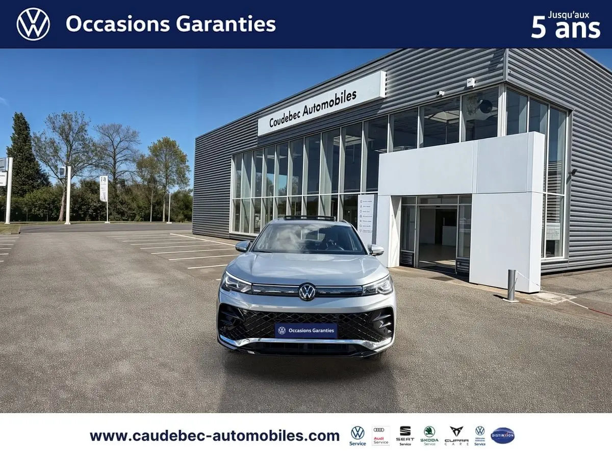 Volkswagen Tiguan 1.5 eHybrid argent Dolomite vu de face, avec toit ouvrant panoramique et calandre noire brillante.