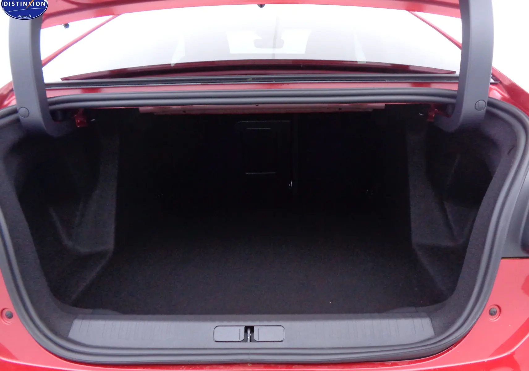 Coffre ouvert de la Citroën C4 X rouge Elixir Metal, vue arrière montrant l'espace de rangement vide.