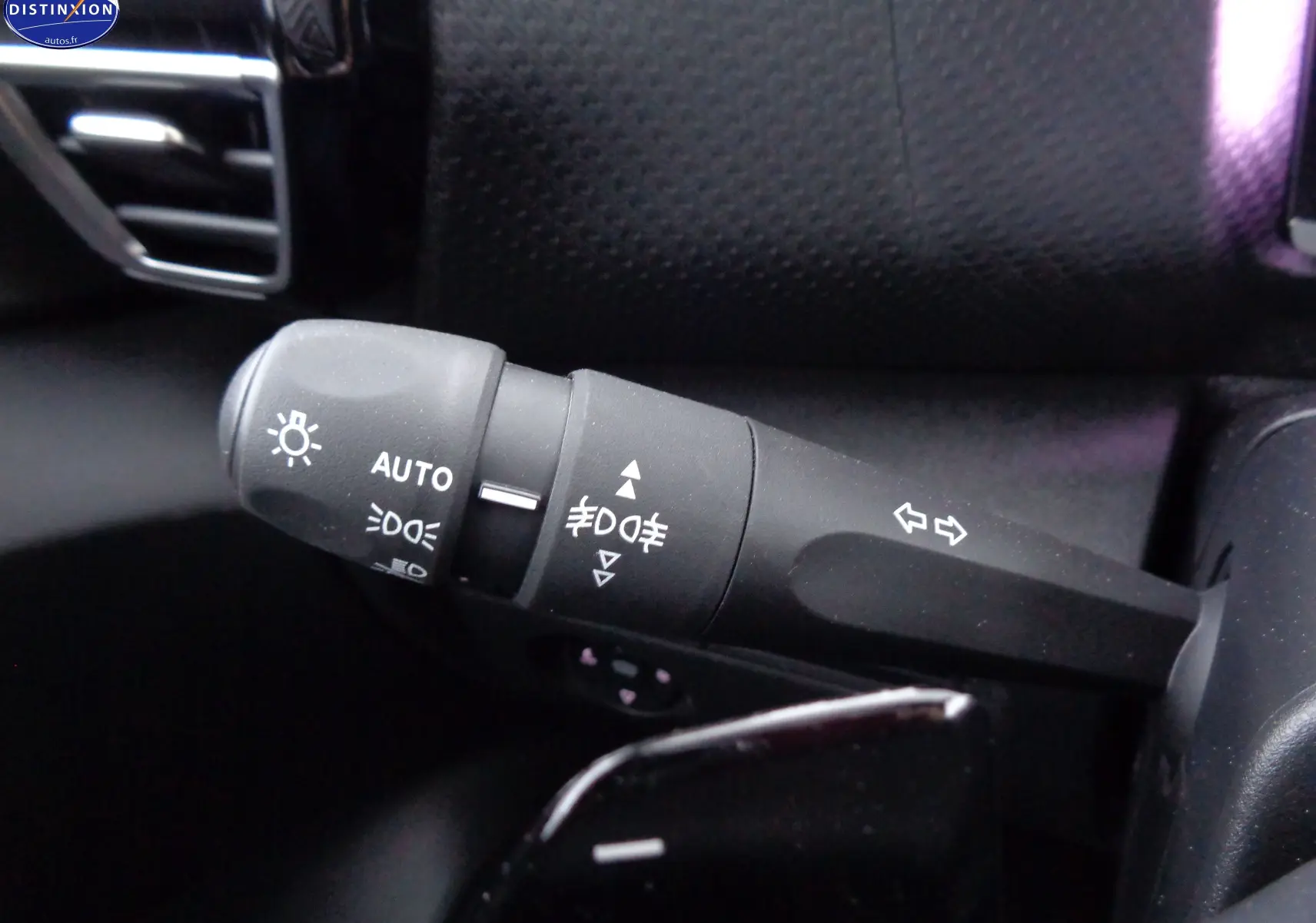 Gros plan sur la commande des phares et clignotants du Citroën C4 X rouge Elixir Metal, version 2023.