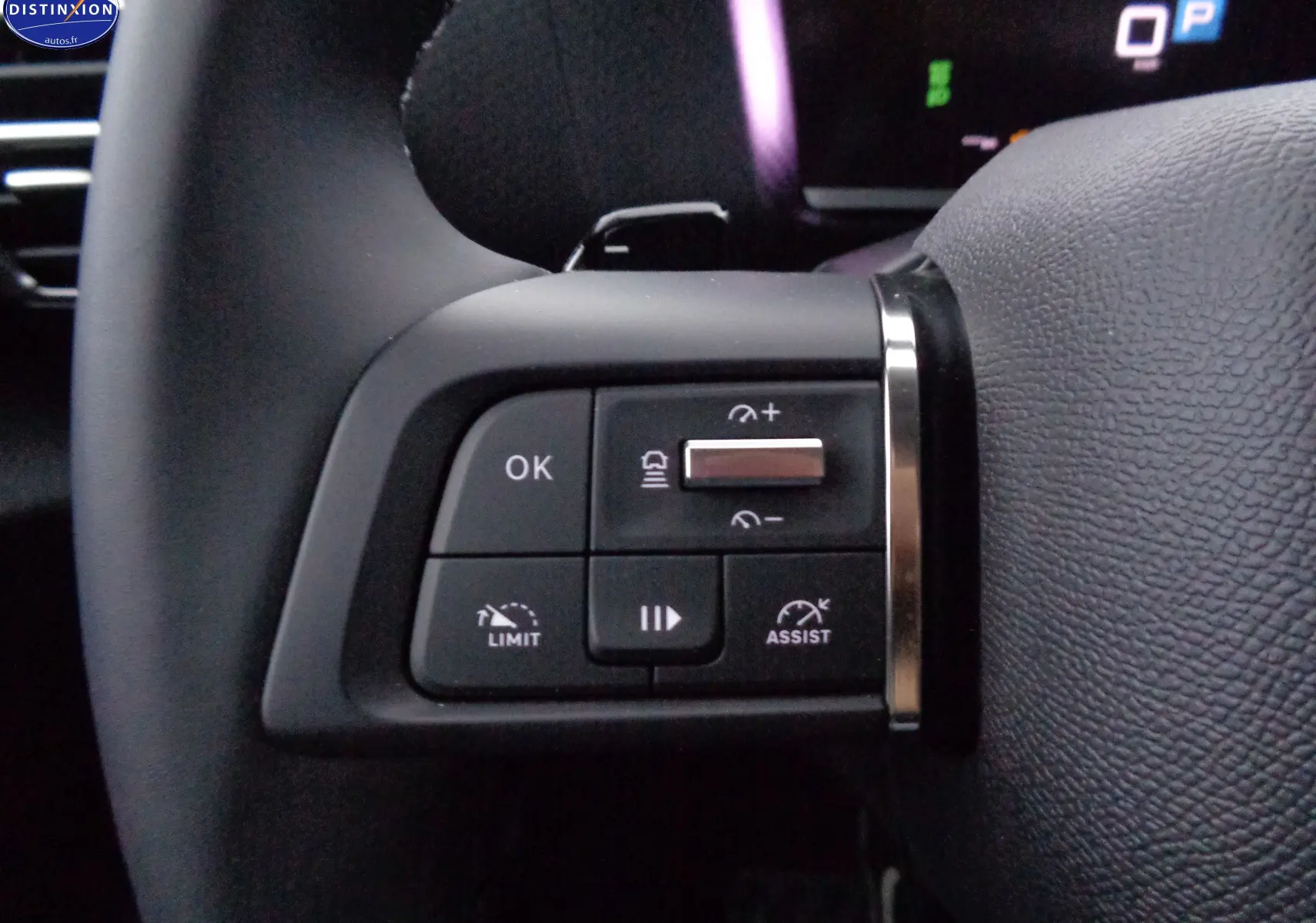 Gros plan sur les commandes au volant à gauche du Citroën C4 X rouge Elixir Metal, boutons de régulateur et assistant de conduite.