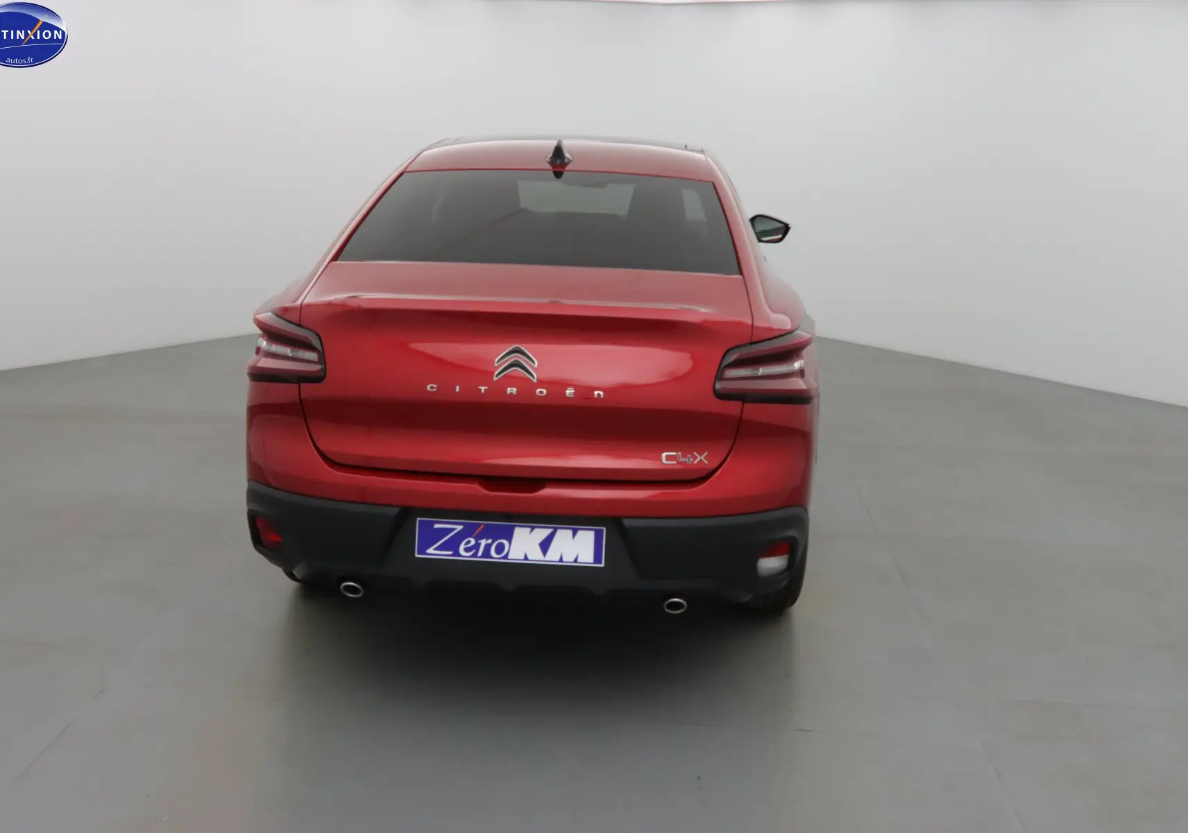 Vue arrière d'une Citroën C4 X rouge Elixir Metal avec feux LED et double sortie d'échappement visible.