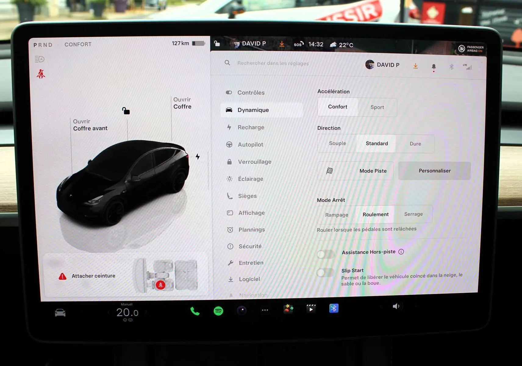 Écran tactile central affichant les réglages de conduite d'une Tesla Model Y noire métal, vue intérieure du tableau de bord.
