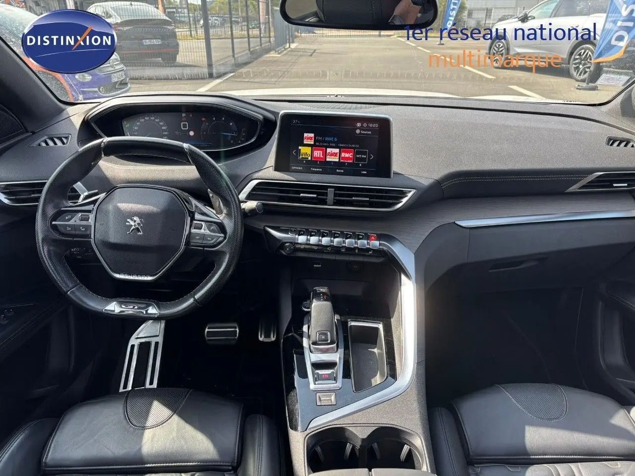 Vue intérieure avant du Peugeot 3008 GT 2018 avec tableau de bord moderne et volant cuir noir.