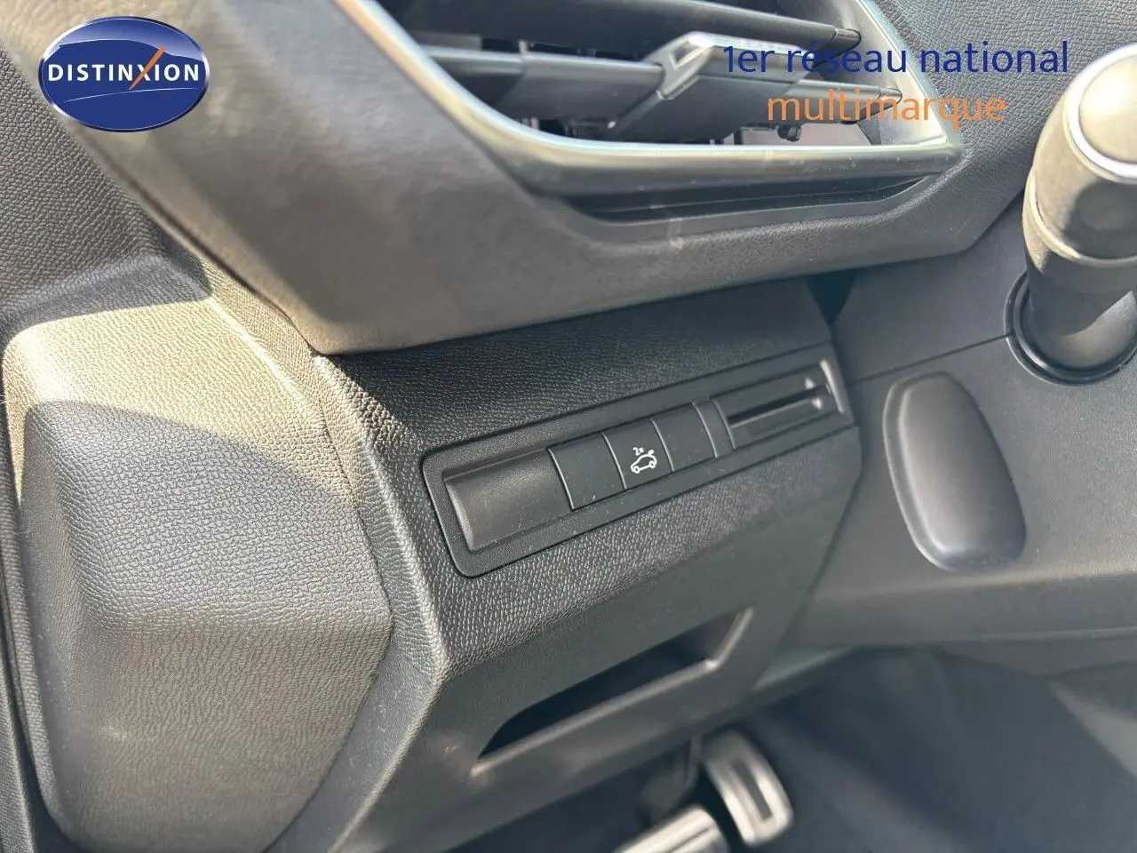 Détail du tableau de bord côté gauche du Peugeot 3008 GT blanc nacré, avec bouton d'ouverture du capot visible.