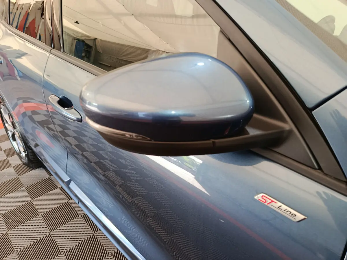 Gros plan sur le rétroviseur côté gauche d'un Ford Kuga bleu 2024 version ST Line avec badge ST Line visible.