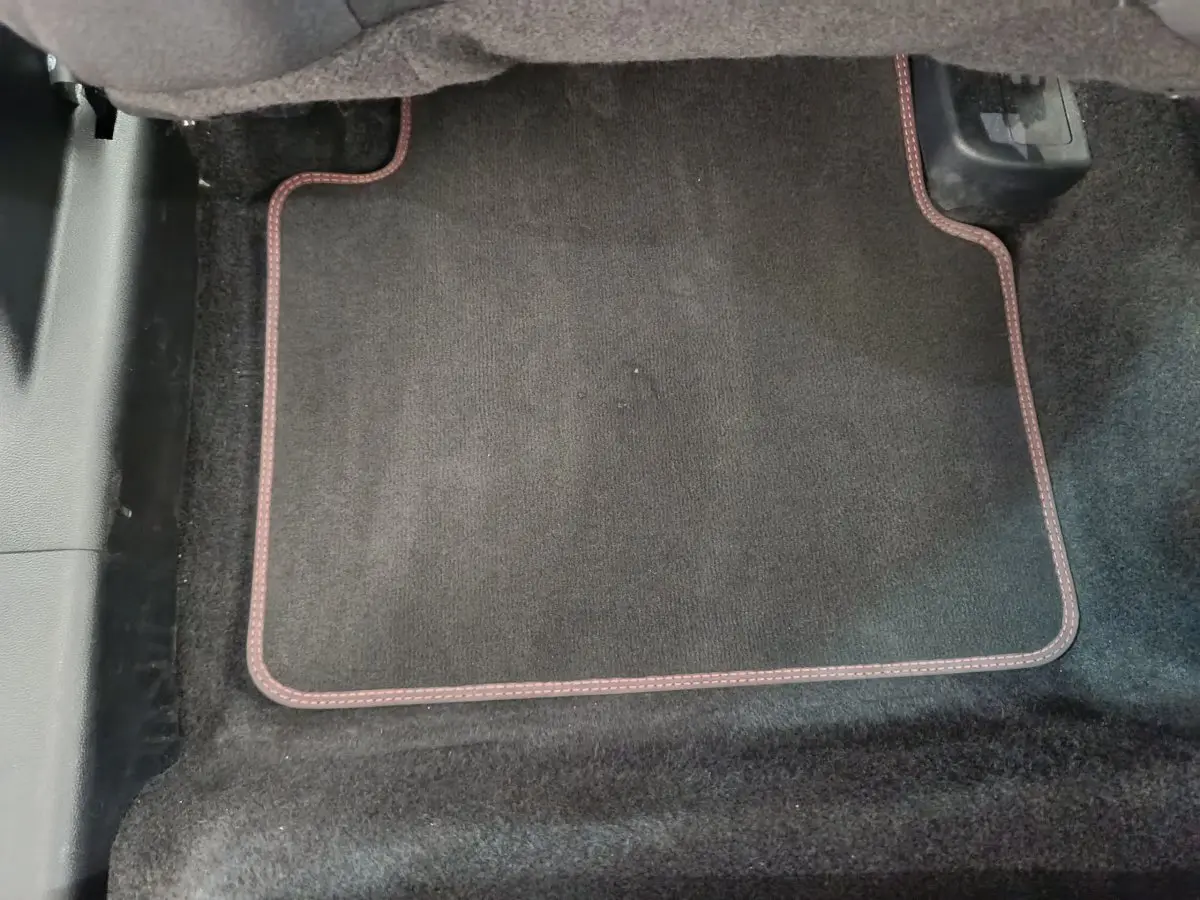 Tapis de sol noir avec surpiqûres rouges dans l'habitacle du Ford Kuga 2024 version St Line.