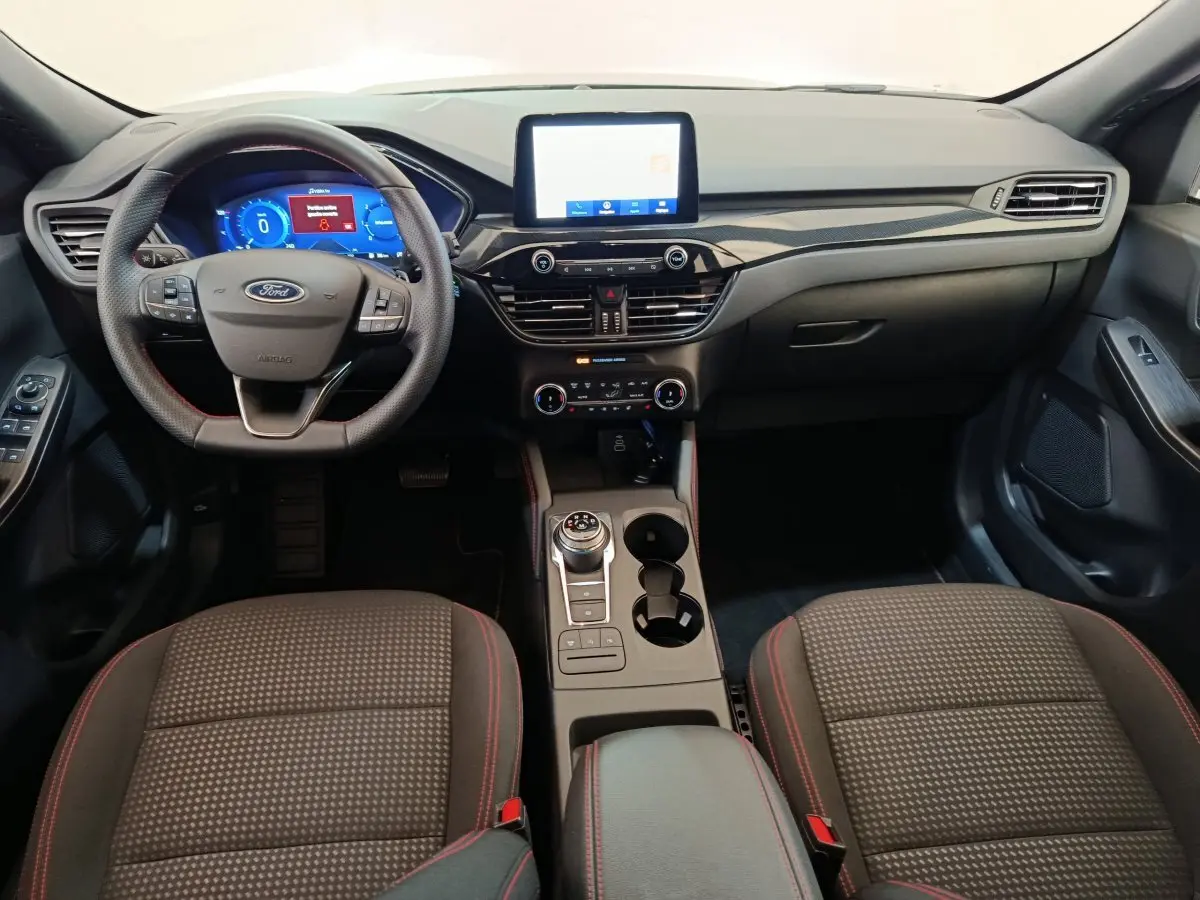 Intérieur du Ford Kuga 2024 St Line, vue frontale du poste de conduite avec écran tactile et volant multifonctions.