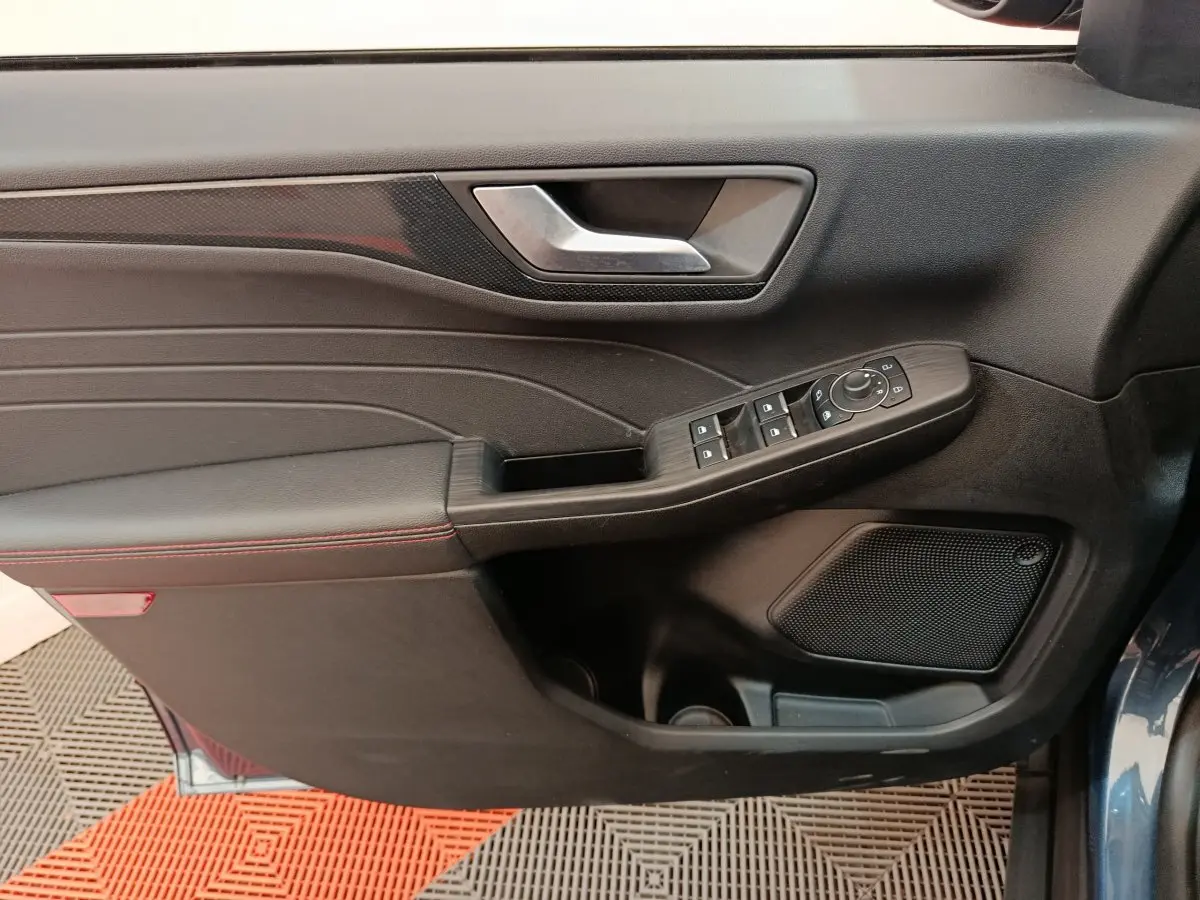Vue rapprochée de la porte côté gauche du Ford Kuga bleu 2024, avec commandes électriques et garniture noire.