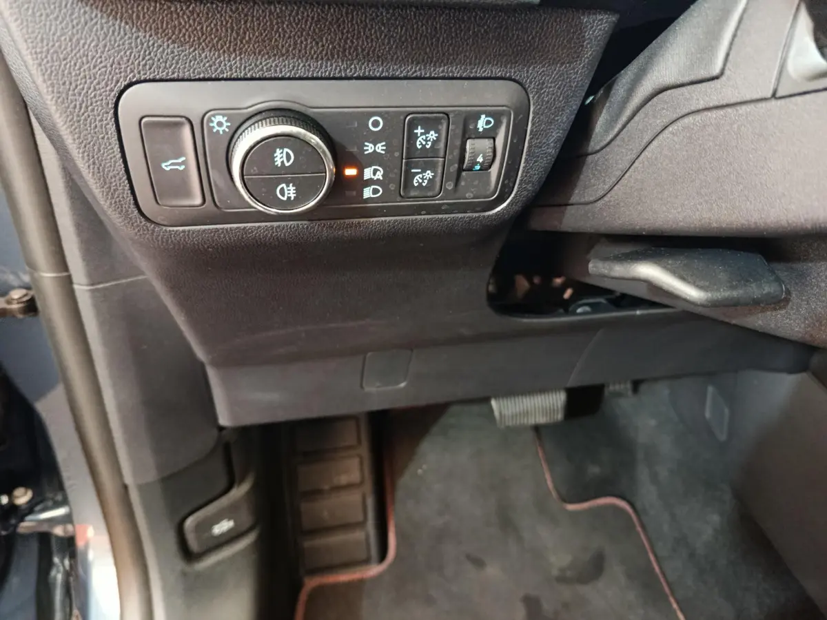 Détail du tableau de bord côté gauche avec commandes d'éclairage sur Ford Kuga bleu 2024 St Line.
