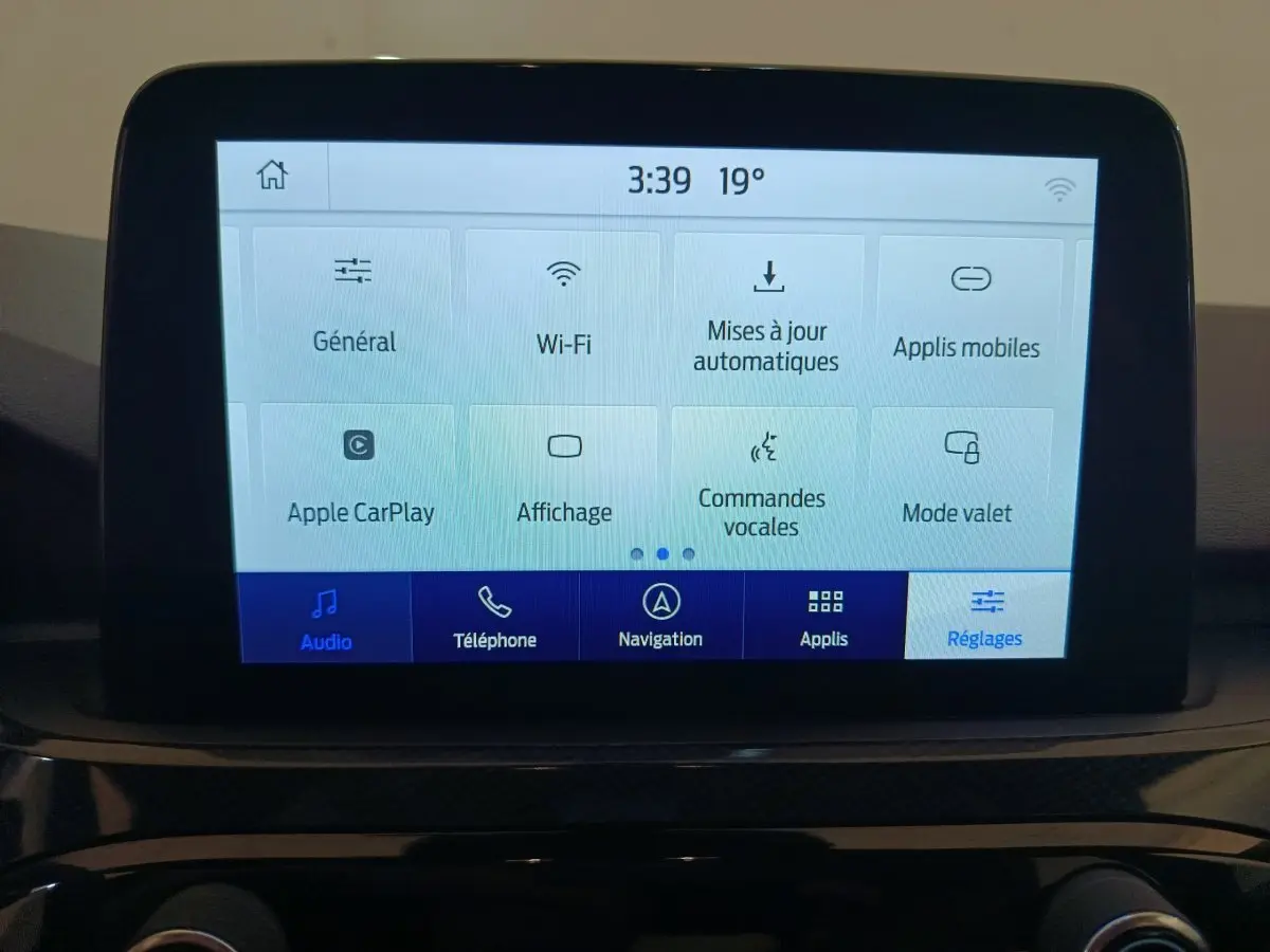 Écran tactile central du Ford Kuga 2024 affichant les réglages Wi-Fi, Apple CarPlay et commandes vocales.