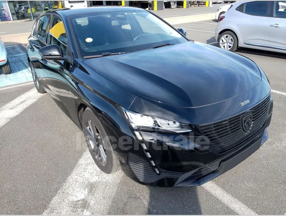 Peugeot 308 noire vue en 3/4 avant droit, mettant en valeur sa calandre moderne et ses phares LED distinctifs.