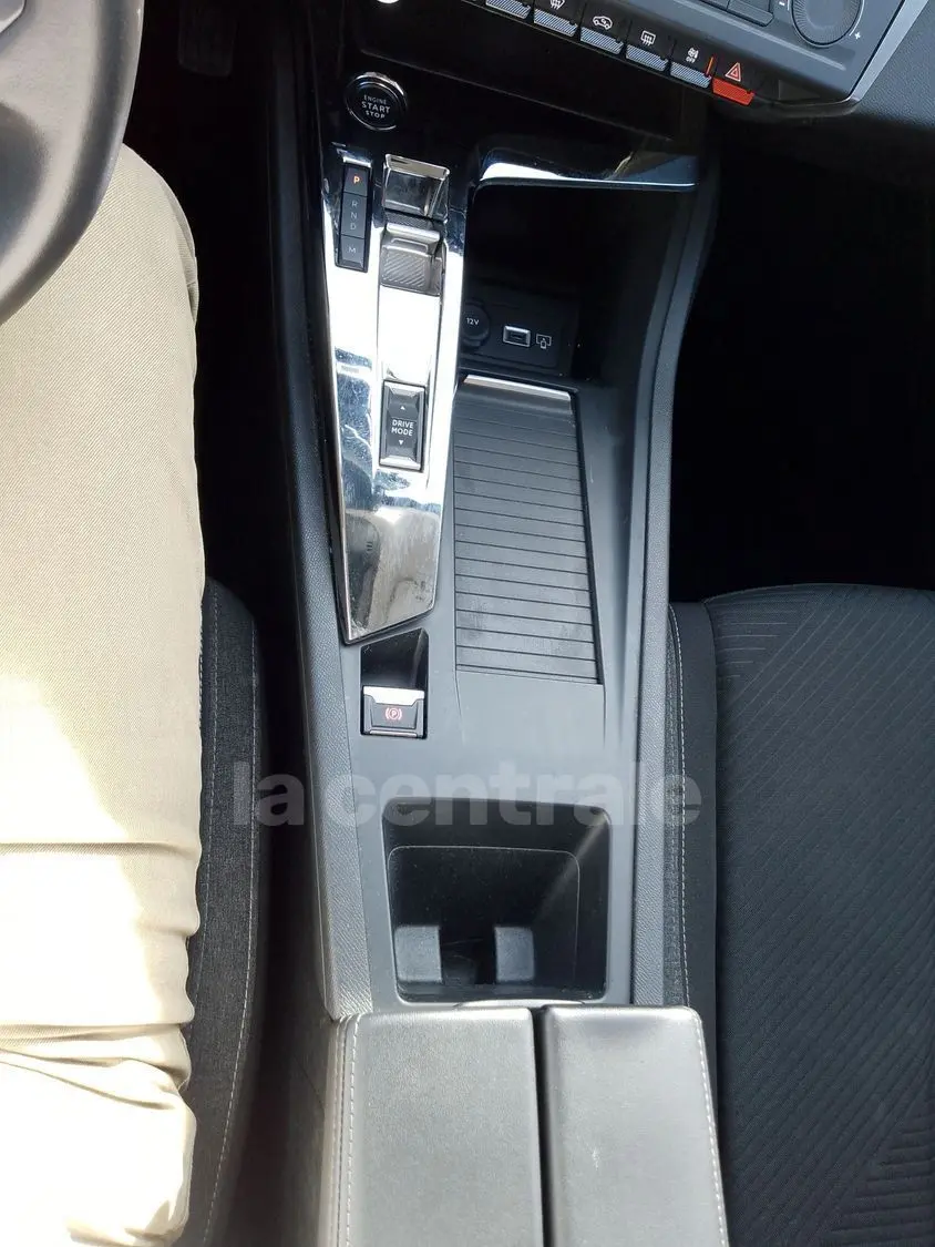 Vue plongeante sur la console centrale noire de la Peugeot 308 2022, montrant levier de vitesses automatique et commandes intégrées.