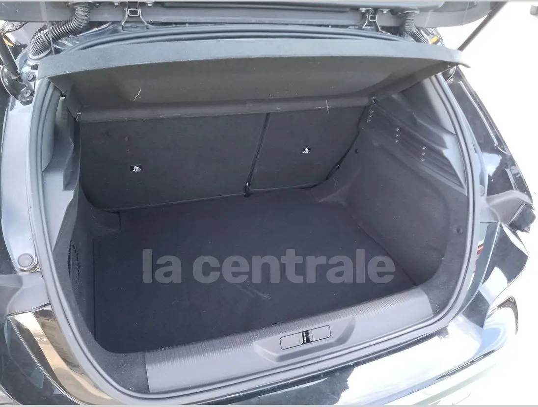 Coffre ouvert d'une Peugeot 308 noire, vue arrière montrant l'espace de chargement vide et la garniture intérieure noire.
